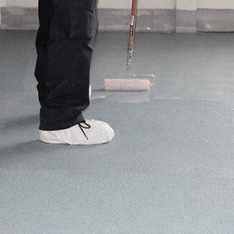 Contractor applying a finish to the epoxy flooring